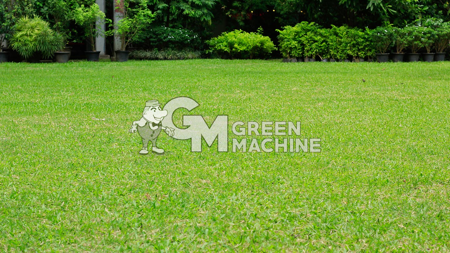 A green, well manicured lawn with Green Machine logo in center